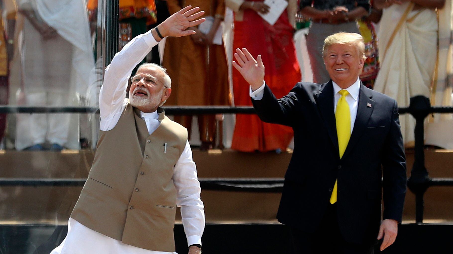 O primeiro-ministro indiano Modi acena ao lado de Trump, nestasegunda-feira no estádio Ahmedabad.