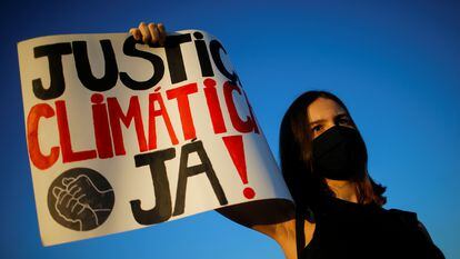 Ativista mostra cartaz pedindo justiça climática durante manifestação em Brasília, em setembro de 2020.