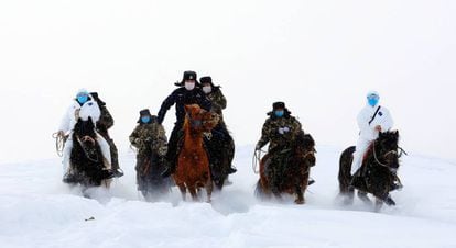 Funcionários chineses viajam através da neve para visitar aldeias remotas e informar sobre o coronavírus. 