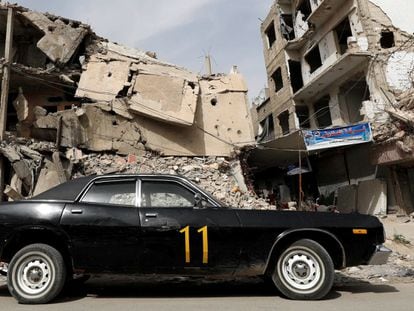 Carro estacionado diante de edifício em ruínas, nesta terça-feira em Duma, na periferia de Damasco.