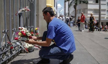 Um homem deixa flores para as vítimas da Catedral de Campinas.