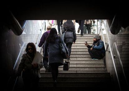 Homem pede esmolas na saída de estação de metrô em Atenas.