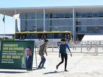 Protesters in front of the Planalto Palace in Brasilia, place a placard reading "President Jair Bolsonaro, why did your wife Michelle receive R $ 89 thousand from Fabricio Queiroz?" on August 27, 2020. - Investigators are probing allegations that "Queiroz took part in a scheme to embezzle the salaries of staff members to then-state legislator Flavio Bolsonaro (President Bolsonaro's son)," the Sao Paulo state prosecutor's office said in a statement. (Photo by EVARISTO SA / AFP)
