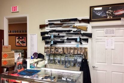 Várias escopetas em uma parede da loja.