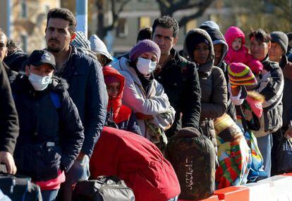 Dezenas de refugiados, neste domingo, na fronteira da Áustria com a Alemanha.
