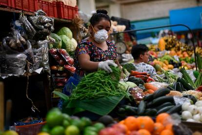 Vendedora de hortaliças num mercado da Cidade da Guatemala