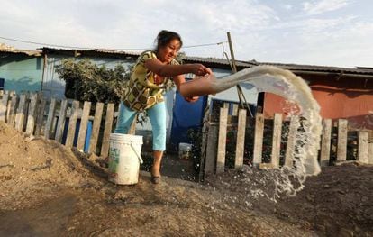 Mulher retira água suja de sua casa em Callao, Peru.