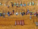 Aerial picture showing a burial taking place at an area where new graves have been dug up at the Nossa Senhora Aparecida cemetery in Manaus, in the Amazon forest in Brazil, on April 22, 2020. - The new grave area hosts suspected and confirmed victims of the COVID-19 coronavirus pandemic. More than 180,000 people in the world have died from the novel coronavirus since it emerged in China last December, according to an AFP tally based on official sources. (Photo by Michael DANTAS / AFP)