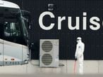 A bus carrying the passengers from the quarantined Diamond Princess cruise ship prepares to leave a port in Yokohama, near Tokyo, Thursday, Feb. 20, 2020. The cruise ship started letting passengers who tested negative for the virus leave the ship Wednesday. Test results are still pending for some people on board. (AP Photo/Eugene Hoshiko)