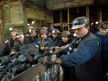 Mineiros rumanos empurram uma carruagem de carvão na localidade de Petrila