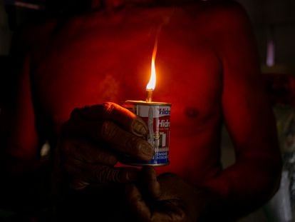 José Silva dos Santos, 55, acende vela em uma latinha de querosene em Provedor II, comunidade de Santana (AP).