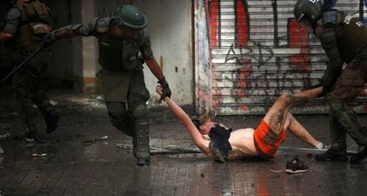 Policiais arrastam a manifestante durante um protesto na segunda-feira em Santiago.