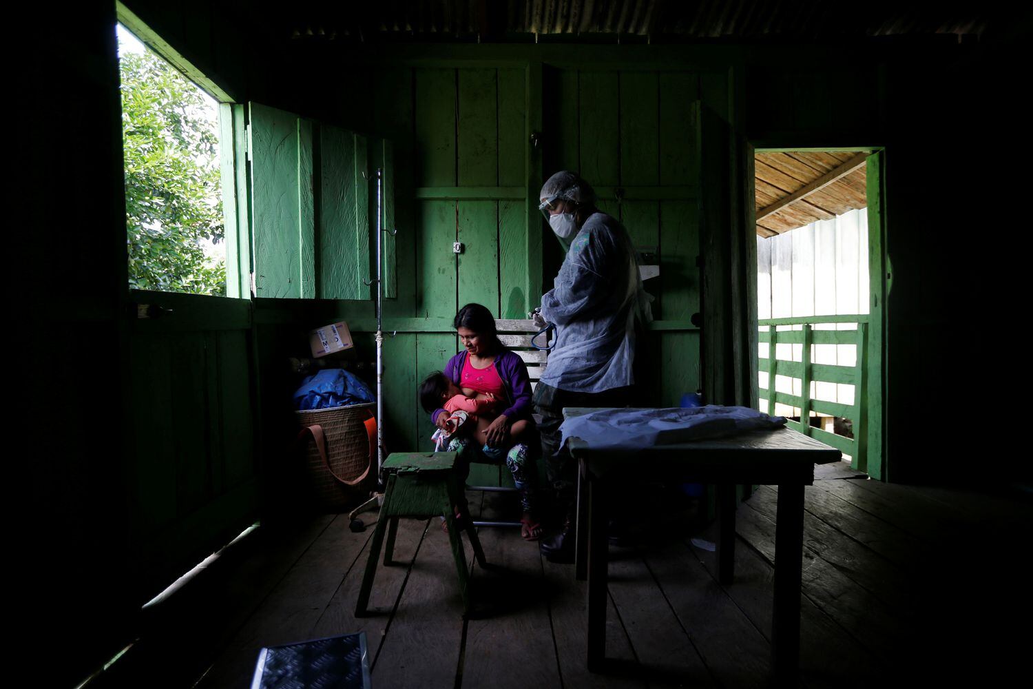 Integrante da equipe médica das Forças Armada examina mulher Yanomami.