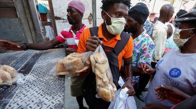 People take food distributed from a truck by a Haitian government program amid the spread of the coronavirus disease (COVID-19), in Port-au-Prince, Haiti April 6, 2020. REUTERS/Jeanty Junior Augustin