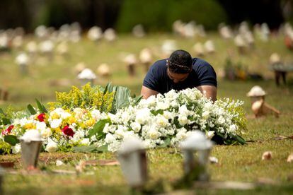 Homem visita uma tumba no cemitério Campo da Esperança, em Brasília, no dia 23 de março.