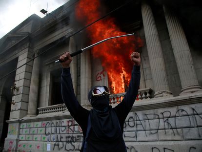 Um homem protesta em frente ao Congresso da Guatemala, que foi incendiado por alguns manifestantes.