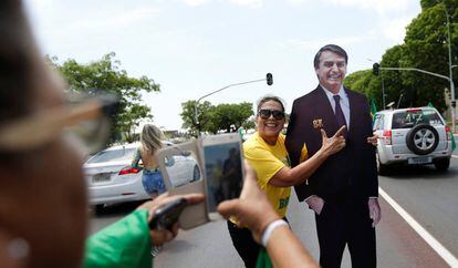Duas seguidoras de Bolsonaro fotografam-se junto a uma figura de cartão do candidato ultraderechista.