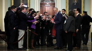 Chuck Schumer, líder da minoria democrata no Senado, ao lado de vários jornalistas na terça-feira.