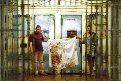 Detentos mostram panos sujos de sangue após o massacre, em outubro de 1992.