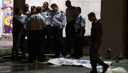 Policiais israelenses junto ao corpo do agressor/ YEHUDA PERETZ (AFP)