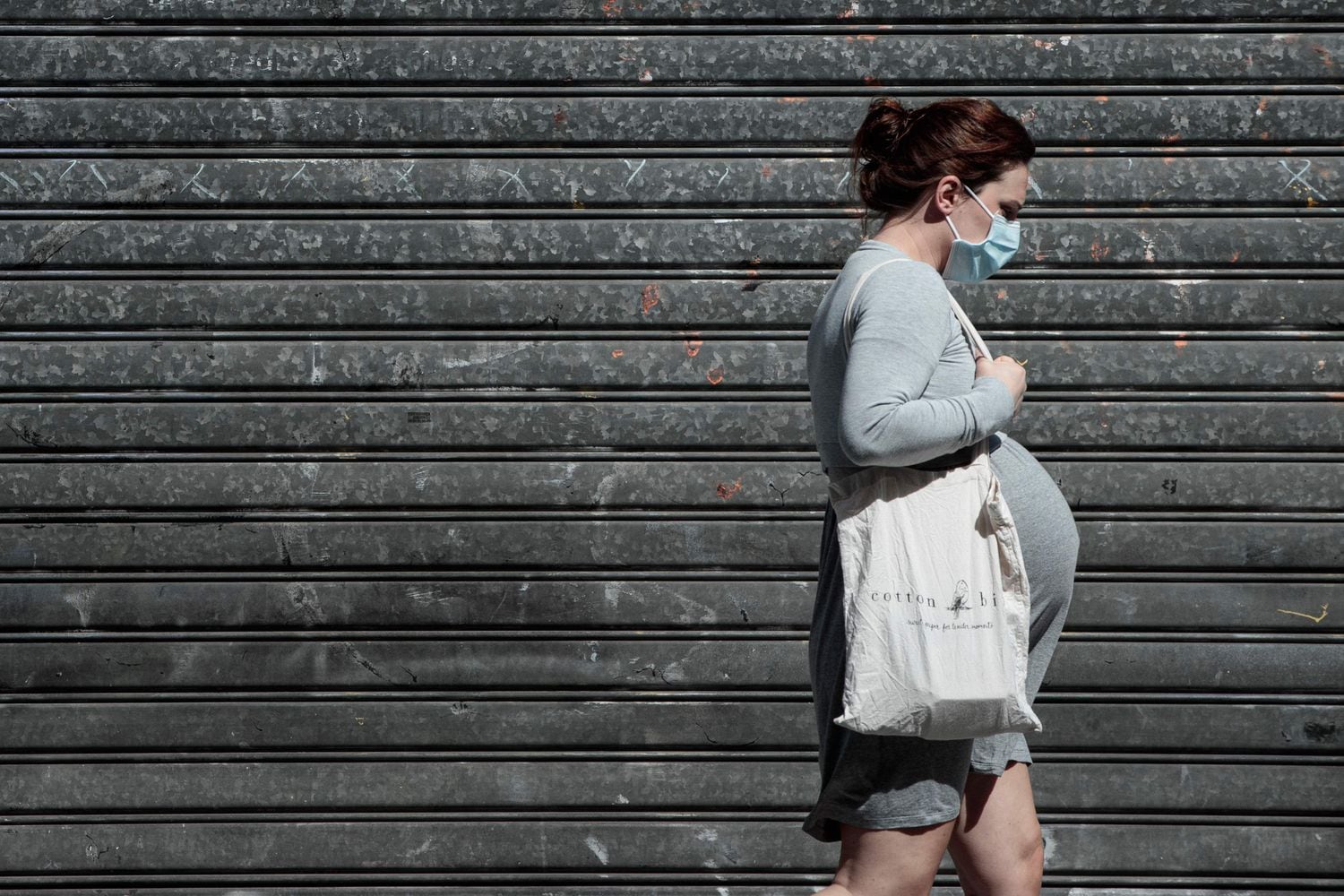 Uma mulher grávida caminha em Paris.