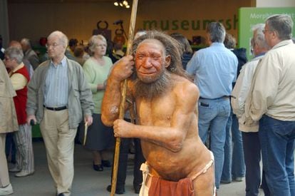 Estátua de um homem de neandertal na porta de um museu.