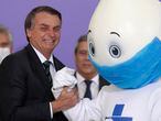 Brazilan President Jair Bolsonaro poses for photos with the mascot of his nation's vaccination campaign, named "Ze Gotinha," or Joseph Droplet, during a ceremony to present the National Vaccination Plan Against COVID-19 at Planalto presidential palace in Brasilia, Brazil, Wednesday, Dec. 16, 2020. (AP Photo/Eraldo Peres)