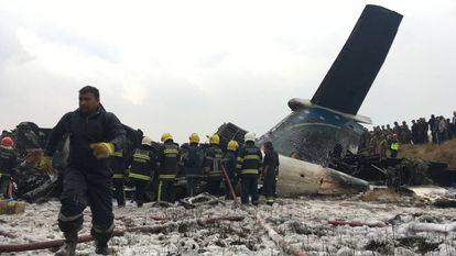 Equipe de resgate junto ao avião procedente de Bangladesh que caiu no Nepal.