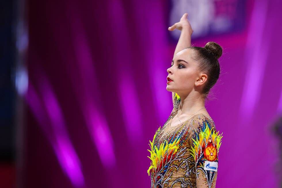 Arina Averina, uma das duas grandes estrelas da ginástica rítmica da Rússia nas Olimpíadas de Tóquio (a outra é sua irmã gêmea, Dina). A ginasta veste um collant repleto de pedrarias e plumas.