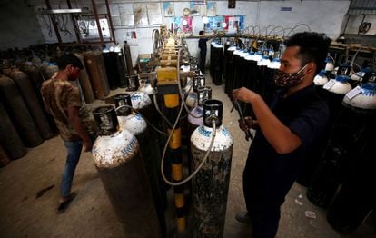 Operários preparam botijões de oxigênio em Bangalore (Índia). 