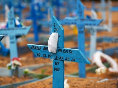 Uma máscara facial é colocada em uma cruz em uma área reservada para o sepultamento das vítimas da Covid-19 no cemitério Nossa Senhora Aparecida em Manaus.