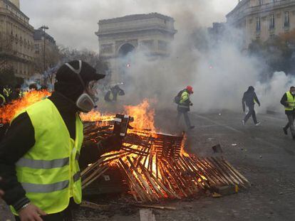 Manifestantes do movimento dos 'chalecos amarelos' em Paris. Em vídeo, a policial dispersa o protesto com gases lacrimógenos
