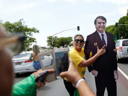 Duas seguidoras de Bolsonaro fotografam-se junto a uma figura de cartão do candidato ultraderechista.
