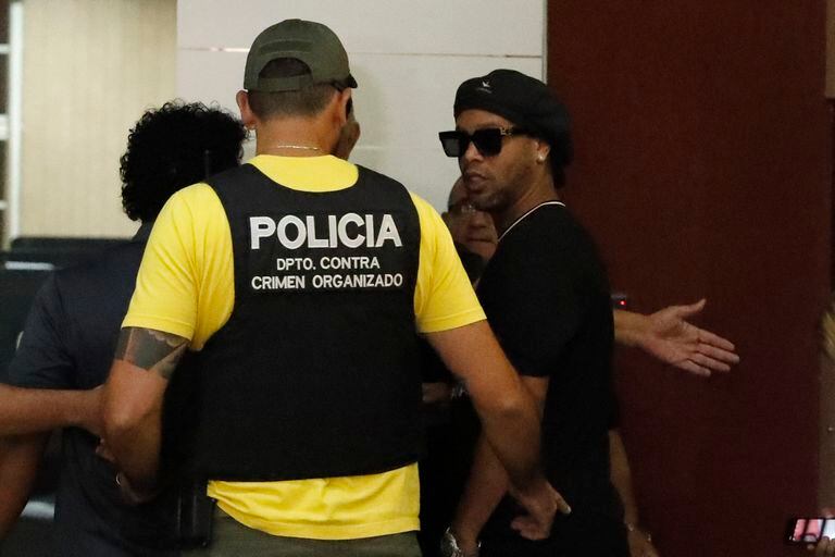 Former Brazilian soccer star Ronaldinho, or Ronaldo de Assis Moreira, right, enters Paraguay's attorney offices in Asuncion, Paraguay, Thursday, March 5, 2020. According to local news, Ronaldinho is accused of arriving in the country with a fake Paraguay passport. (AP Photo/Jorge Saenz)