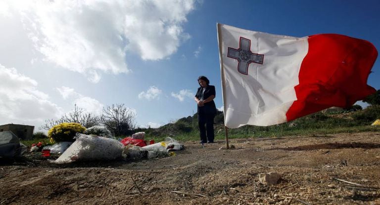 Mulher visita o local do assassinato da repórter Daphne Caruana Galizia.