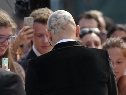 James Franco, de costas e com a cabeça raspada, concede autógrafos no festival de Veneza.