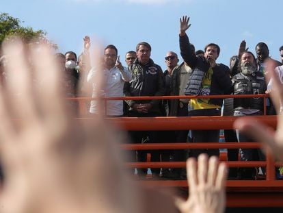 Apoiadores de Jair Bolsonaro levantam as mãos em oração após passeio de moto em São Paulo.