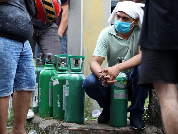 Relatives of patients hospitalised or receiving healthcare at home, mostly suffering of COVID-19, gather to buy oxygen and fill cylinders at a private company in Manaus, Brazil January 15, 2021. REUTERS/Bruno Kelly