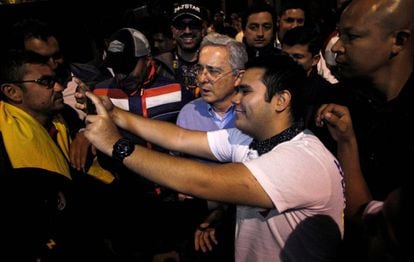 O ex-presidente colombiano Álvaro Uribe posa para um ‘selfie’ com um partidário do ‘não’ ao acordo de paz, no domingo.