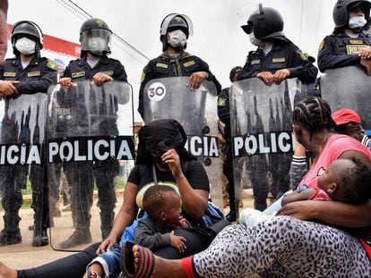 Duas mães migrantes diante do bloqueio policial na cidade peruana de Iñapari, na fronteira com o Brasil, na quinta-feira.