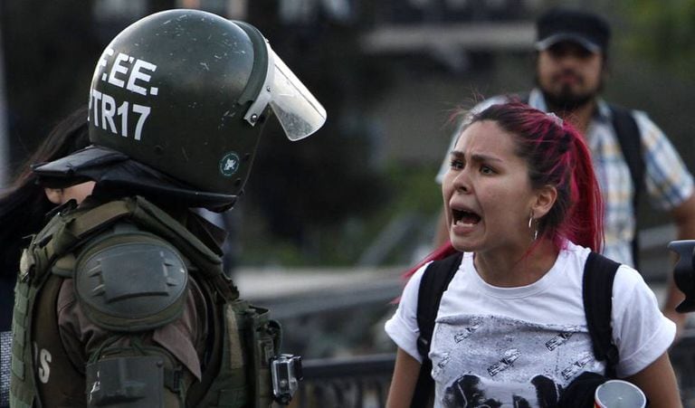 Uma manifestante discute com um carabineiro nos protestos de Santiago.