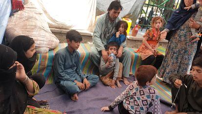 Gul Khan (à esq., com a mão no rosto) com membros de sua família no parque Shahr-e Now, em Cabul, onde vivem acampados há dois meses.