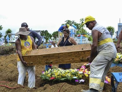 Familiares enterram os mortos durante o massacre de Manaus.