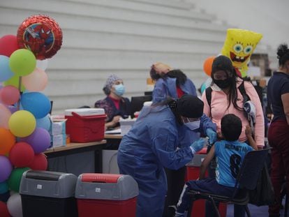 Uma funcionária de unidade de saúde administra uma vacina da Sinovac a uma criança em Cuenca, Equador, em 23 de novembro.