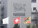 A Swiss national flag flies beside a flag of the canton of Bern in front of the logo of Nestle at a plant in Konolfingen, Switzerland September 28, 2020. REUTERS/Arnd Wiegmann
