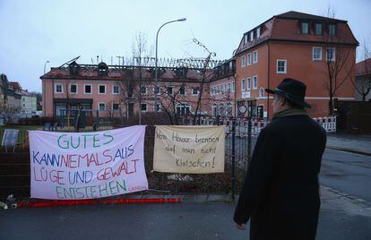 Um homem diante de faixas de protesto contra o incêndio de um hotel, na segunda-feira em Bautzen (Alemanha).