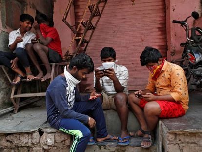 Um grupo de jovens checa seus celulares em Bombaim.