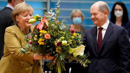 A chanceler alemã em exercício, Angela Merkel, recebe um buquê de flores de seu futuro sucessor, Olaf Scholz, na manhã de quarta-feira, antes do que provavelmente será seu último Conselho de Ministros.