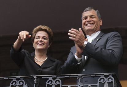 Os presidentes do Brasil, Dilma Rousseff (à esq.), e do Equador, Rafael Correa, acenam de uma sacada em Quito.