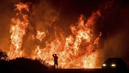 Um homem observa desde a estrada o incêndio de Ventura, Califórnia, na quinta-feira.